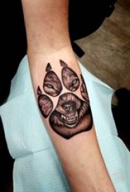 Brațul băiatului cu imprimeu laba la negru cu punct gri și poză mică cu tatuaj lup de animale