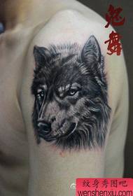 Cara del brazo con un patrón de tatuaje de cabeza de lobo serio