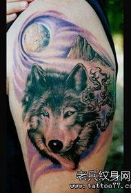 a dull wolf head tattoo on the arm