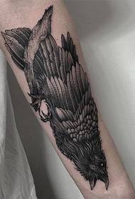 un tatuaggio aquila solitario in piedi su un ramo morto