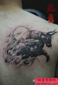 Spalle da ragazzo e feroce motivo a tatuaggio di mucca
