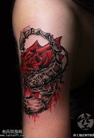 štír kolem ohromujícího růžového tetovacího vzoru