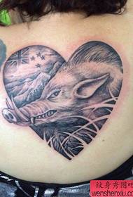 një model klasik i tatuazheve të derrit të egër në anën e pasme të vajzës
