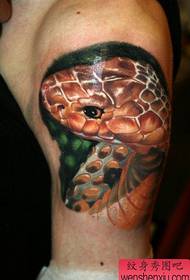 हातावर एक अतिशय वास्तववादी साप टॅटू