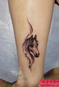 Un classico modello di tatuaggio a cavallo sulla gamba della ragazza