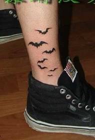czarny wzór tatuażu nietoperza na zewnętrznej stronie nogi