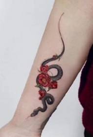 slika prekrasne male crne zmije s umjetničkim djelom tetovaže crvenog cvijeta