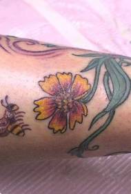 kāju krāsas ziedi un bišu tetovējums