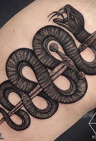 en lårpil som bär ett tatueringsmönster för ormar