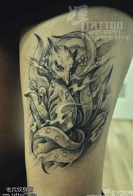 ຮູບແບບ tattoo Fox Fox ທີ່ມີຫາງເກົ້າຢູ່ເທິງຂາ