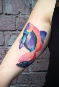 Der Arm des Mädchens gemalt auf kreativem Tätowierungsbild der kleinen Tierfische der Steigung