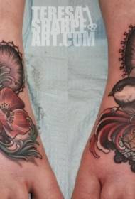 Beautiful colored flowers and bird tattoos on the instep