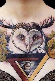 Татуировка с изображением совы на груди