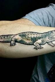 Ramię chłopca na czarno-szarym punkcie ciernia prosta linia małego zwierzęcego tatuażu krokodyla