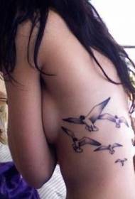 Әйел беліндегі қара сұр құс татуировкасы