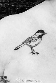 un tatuaggio a forma di uccello sulla spalla