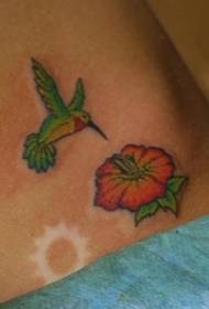 Braccio color colibrì e motivo floreale a tatuaggio