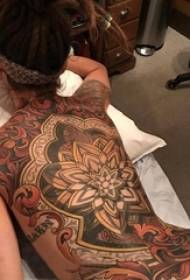 La scolara sul retro ha dipinto le linee astratte semplici le immagini del tatuaggio dei fiori della pianta