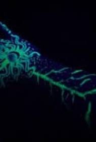 green fluorescent tattoo pattern on the arm