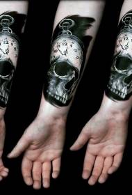 kleine zwart-witte klok in combinatie met een tattoo met schedelarmen