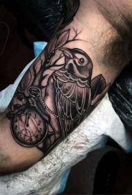 combinazione di divertimentu di bracciu uccellu neru cù un mudellu di tatuaggi di orologio