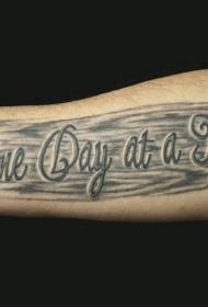 braç masculí en el model de tatuatge de fons negre i lletra