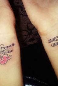 手腕可爱的粉红色花朵和拉丁文字母纹身图案