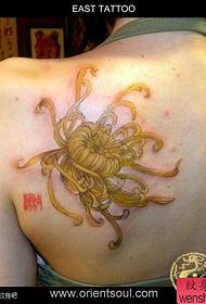 Schéint Meedche Chrysanthumum Tattoo op der Réck vum Meedchen