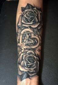 Рука хлопчыка на малюнку татуіроўкі ружовага расліны на чорным шыпе