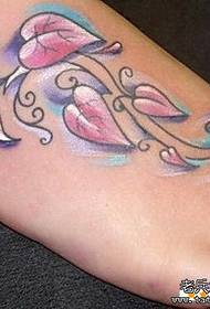 Дівчина красиво виглядає візерунок татуювання листя