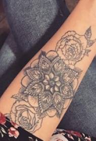Brazo de colegiala en espina negra línea abstracta planta flor tatuaje foto