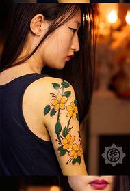 Tüdruku käsivarrel ilus ja ilus lilleline tätoveeringu muster
