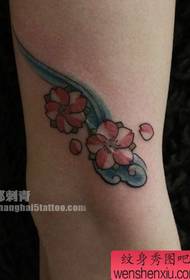 Дјевојчица дијете краси лијеп узорак тетоваже са цвјетањем трешње