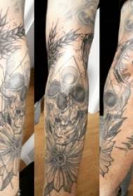 검은 회색 가시 식물 꽃과 해골 문신 사진에 소년의 팔