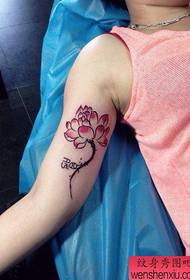 Bellu mudellu di tatuaggi di lotus femminile à l'internu di u bracciu di a zitella