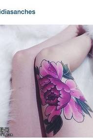 Modello coscia sexy e delicato con tatuaggio di peonia