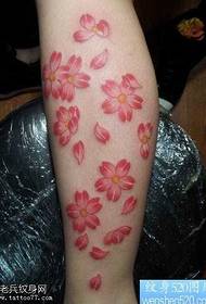 Fermosa tatuaxe en flor de cereixa nas pernas