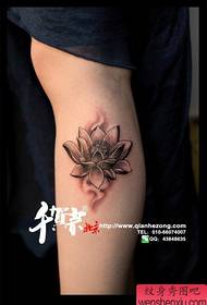 Yon modèl tatoo lotus nwa ak blan ki popilè nan bra a