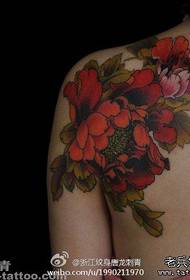 Spalle femminili bellissimo e popolare modello di tatuaggio tradizionale fiore di peonia