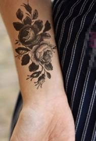 Der Arm des Mädchens auf kreativem schönem Blumentätowierungsbild der schwarzen grauen Skizze