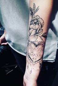 Braccio da ragazza su schizzo grigio nero a forma di cuore creativo e foto tatuaggio fiore