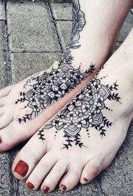 Smieklīgs melnbaltu ziedu tetovējuma modelis uz kājas