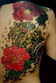 Színes koponya és virág tetoválás, amely fele a hátát