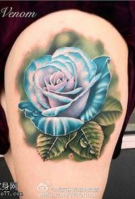 Zilo rožu tetovējuma raksts augšstilbā