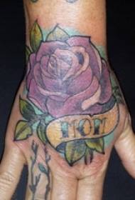 La mano della ragazza sul retro ha dipinto ad acquerello l'immagine del tatuaggio del bello fiore rosa