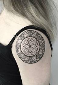 Dievčenská ruka na čiernom vztýčenom geometrickom riadku okolo kvetinovej tetovacej fotografie