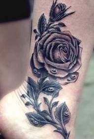 Gražus juodos pilkos rožės tatuiruotės raštas ant kojų