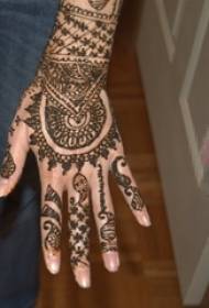 Kvinnlig hand på baksidan av den svarta linjen kreativa vanilj vackra armband tatuering mönster