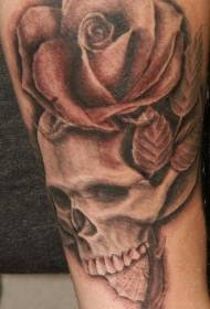 Na ramenu smeđi oblik tetovaže ruža i lubanja