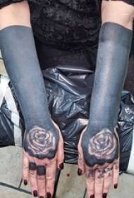 Dievčenská ruka na kreatívnom čiernom umelom atramente, krásna kvetina, tetovanie rukopisu